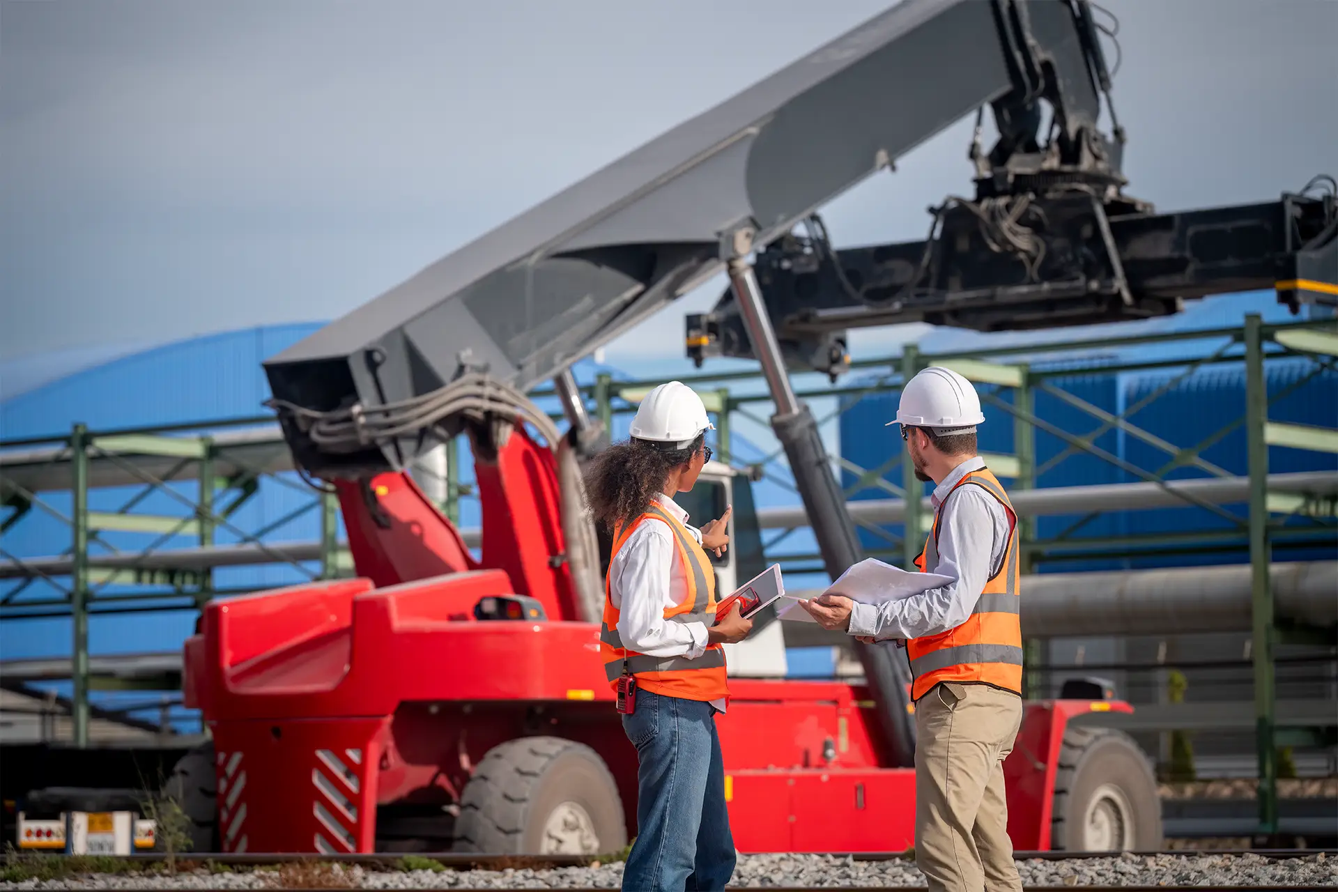 employees discussing and crane parked in background