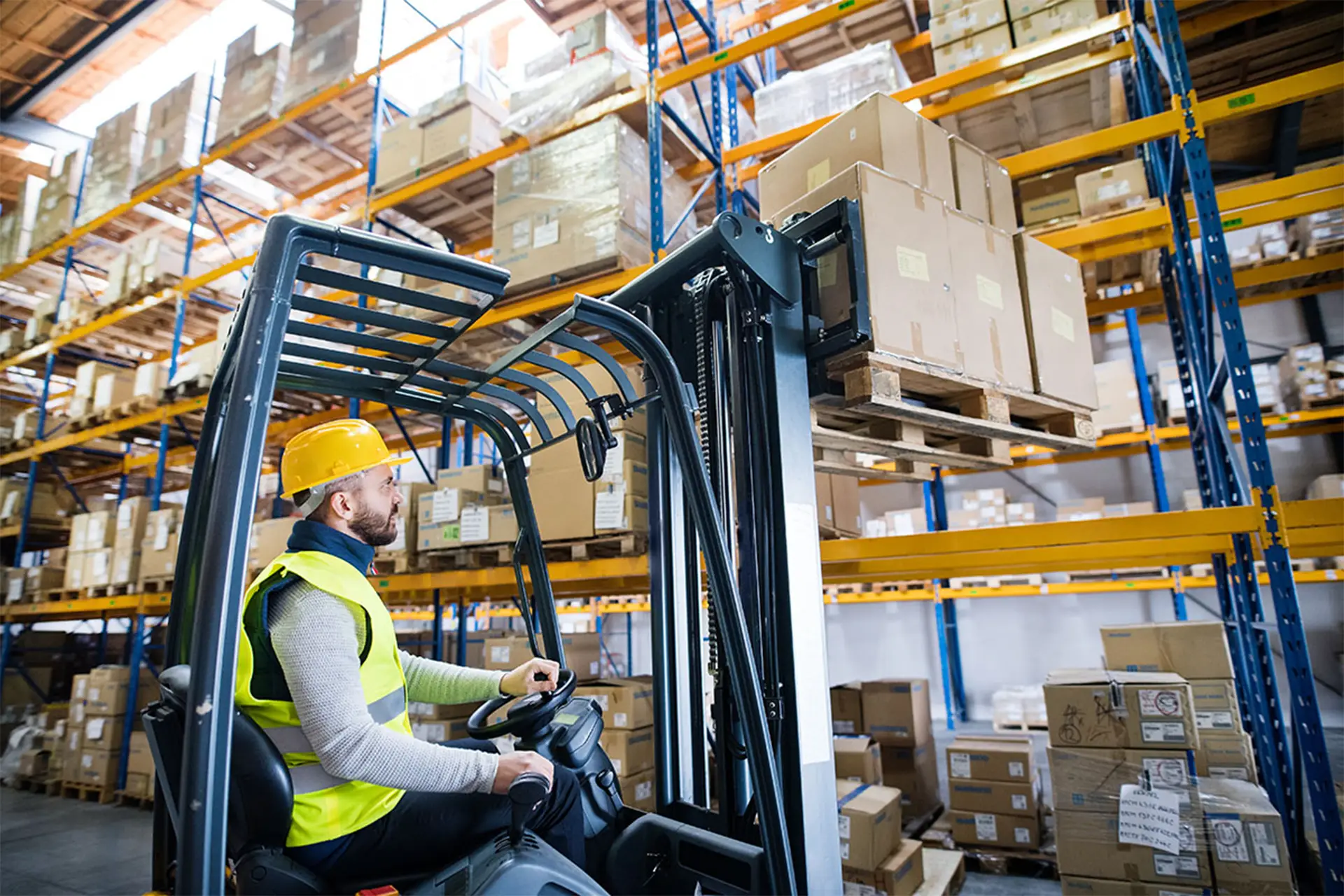 employee arranging cargo using forklift in warehouse